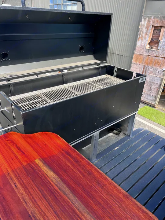 Large black grill with open lid & grates for outdoor cooking. Perfect amenity for your RV rental stay!. Airstream Custom 1957