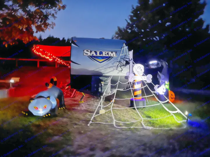 Halloween decorated RV rental at a dark campsite, featuring a glowing cat, spiderweb, skull, pumpkin, and bright lights.. Forest River Salem 2019