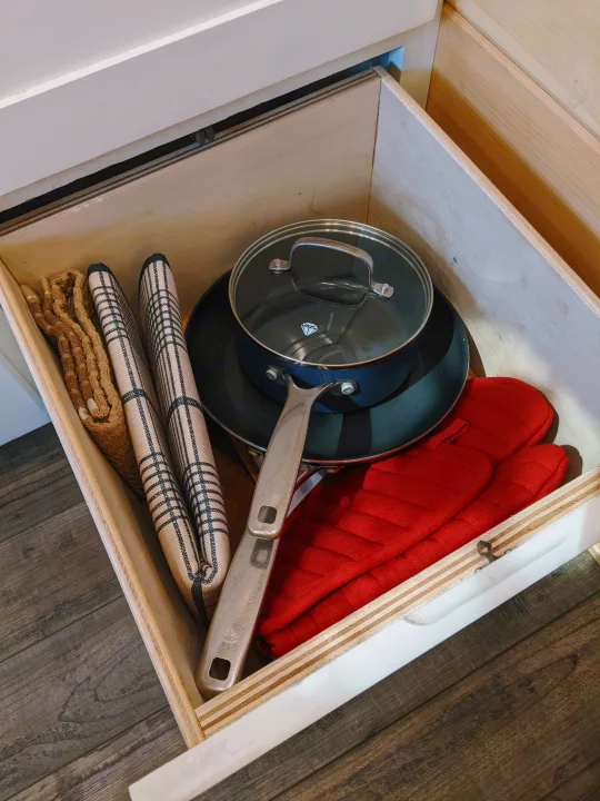 Organized RV kitchen drawer with cookware, towels, and oven mitts for easy access in your RV rental.. Sprinter Mercedes 2018