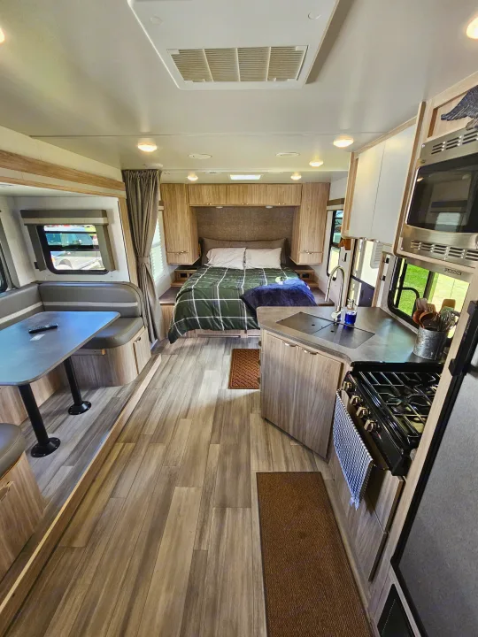 Step inside this RV rental! Features a full bed, dining booth, and complete kitchen, offering comfort for your travel adventures.. Winnebago Minnie 2201MB 2022