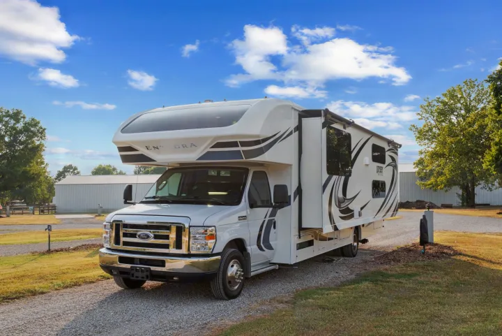 White Class C RV rental with sleek black and grey graphics, ideal for travel and outdoor adventures.. Entegra Coach Odyssey 2020