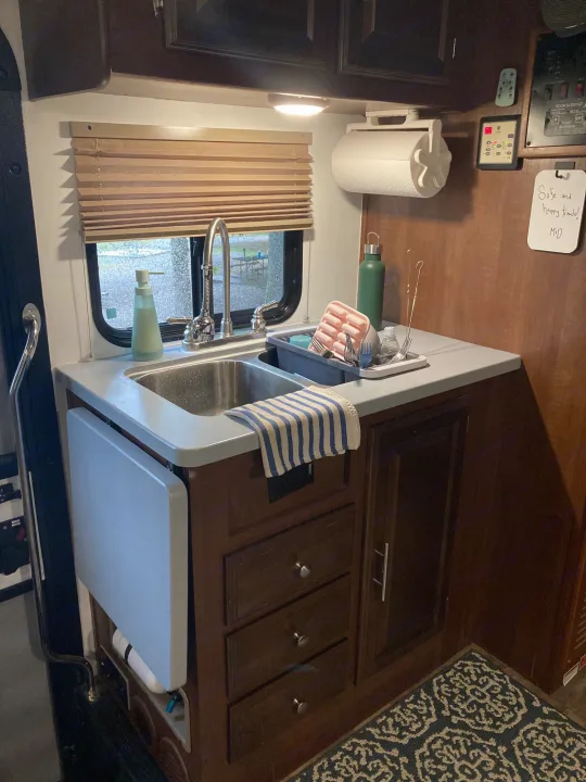 Cozy RV kitchen setup, perfect for your next rv rental adventure. Features include a sink, drying rack, and extendable counter.. Georgetown GT3 2016
