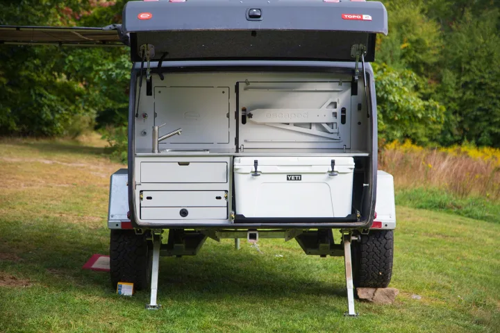 Topo 2 RV rental: This compact camping trailer reveals an equipped outdoor kitchen with sink, drawers, and YETI cooler.. Escapod Topo 2 Voyager 2024
