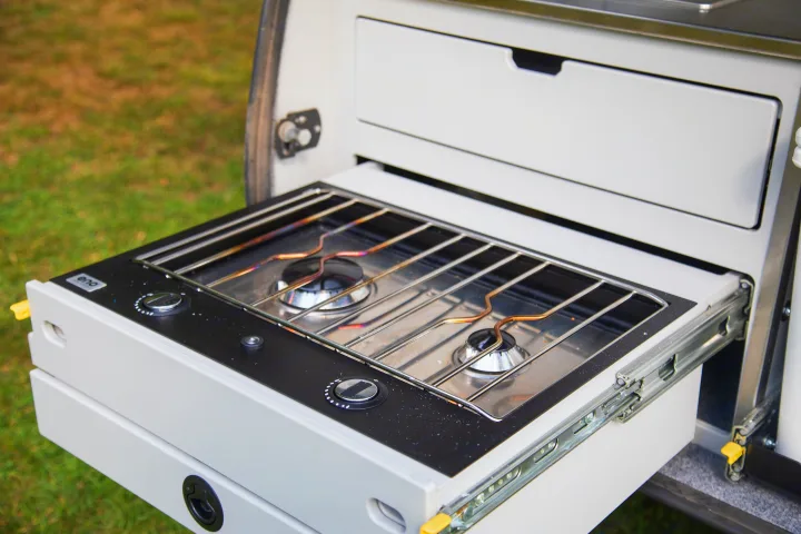 This RV rental reveals a practical pull-out two-burner gas stove with controls, ready for convenient outdoor cooking.. Escapod Topo 2 Voyager 2024