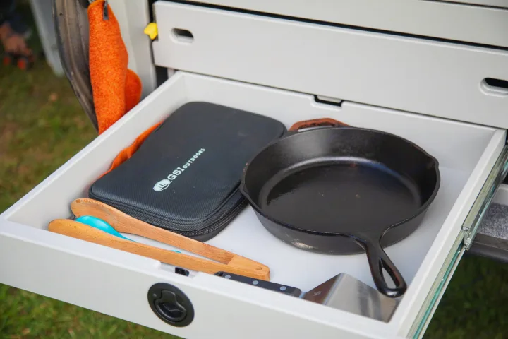 RV rental drawer with camp kitchen essentials: GSI Outdoors case, cast iron skillet, utensils, and spatula.. Escapod Topo 2 Voyager 2024