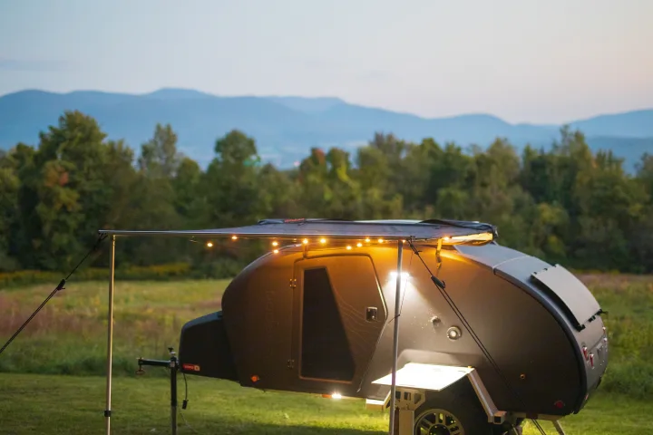 Experience serene nights in an RV rental! This sleek, lit teardrop camper offers cozy camping under an awning with mountain views.. Escapod Topo 2 Voyager 2024