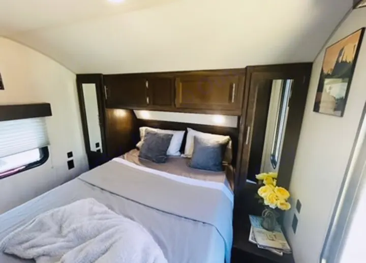Cozy RV rental bedroom with comfortable bedding and ample storage, perfect for your next adventure.. Forest River Cherokee Grey Wolf 2019