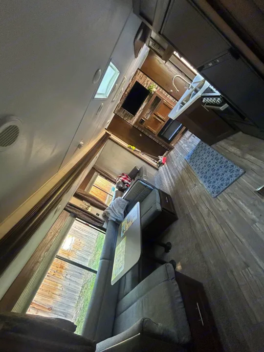 RV rental interior: cozy living area with sofa, full kitchen, and stylish wood-look flooring. Ready for your journey.. Forest River Cherokee Grey Wolf 2019