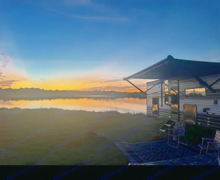 Experience tranquil moments! This RV rental by a lake at sunset showcases a vibrant sky reflecting on calm water. Ideal for camping getaways.. Forest River Cherokee Grey Wolf 2024