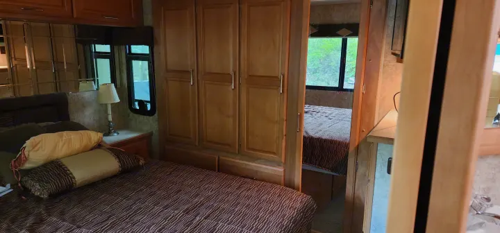 RV rental: Spacious interior showing a cozy bedroom with mirrored cabinets and a second bedroom visible through the doorway.. Winnebago Journey 2006