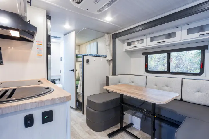 Spacious RV rental interior features a modern kitchen, convertible dinette, and bunk beds for family travel.. No Boundaries 19 2023
