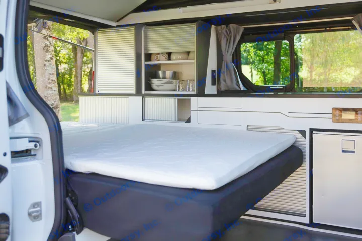 Explore this RV rental's camper van interior: a cozy bed, integrated kitchenette with storage, and fridge.. HANROAD TREK 5 2026
