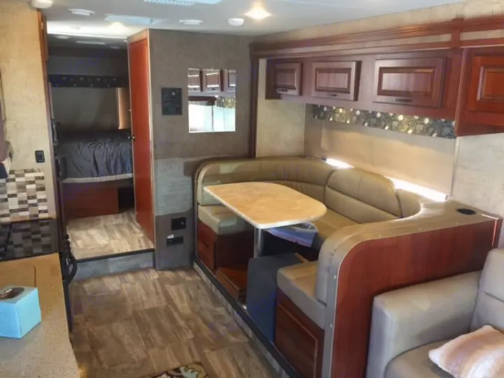 Inside a well-appointed RV rental: view of the comfy dining area, kitchen counter, and private bedroom beyond.. Forest River Forester 2016