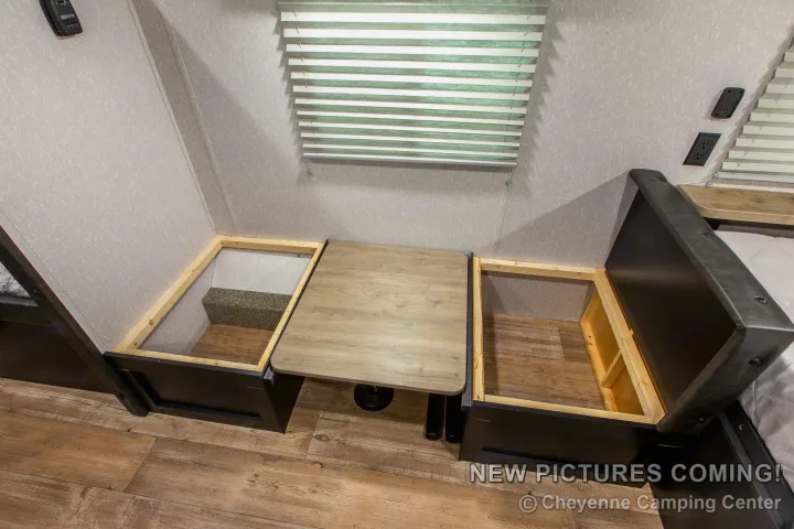This RV rental features a cozy dinette with lift-up bench storage and an adjustable table, ideal for travel and camping.. Forest River Cherokee Wolf Pup Black Label 2022