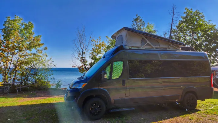 Enjoy lakefront views in an RV rental! This dark camper van with a pop-top is ready for adventure by the water.. Airstream Rangeline 2024