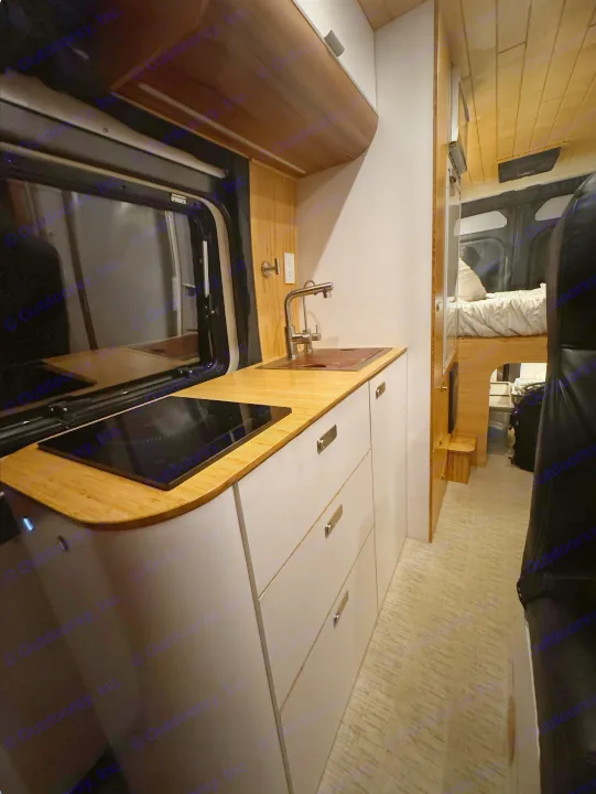 Step inside this modern RV rental! Features a sleek kitchen with sink & induction cooktop, plus a cozy sleeping area.. Noovo Pop 2024