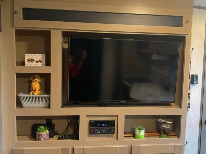 RV rental's entertainment center with TV, stereo, and playful camping decor, ready for cozy travel memories.. Heartland RVs Sundance Ultra Lite 2021