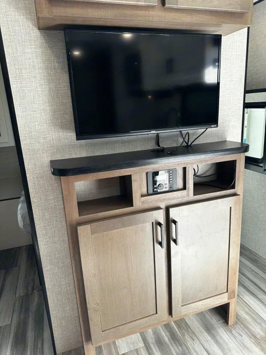 RV rental: Modern entertainment center with TV, media console, and light wood cabinets, ideal for travel comfort.. Jayco Jay Flight 2024
