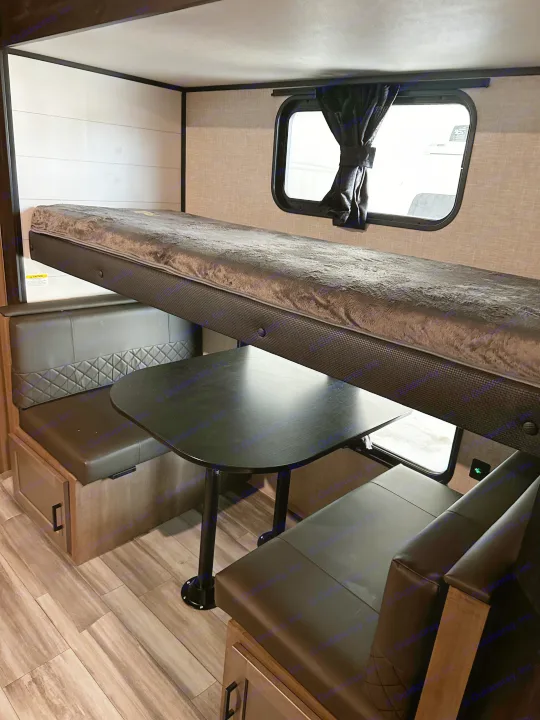 Inside an RV rental: a flexible space with a folded bunk bed above a comfortable dinette. Ideal for travel adventures.. Jayco Jay Flight 2024