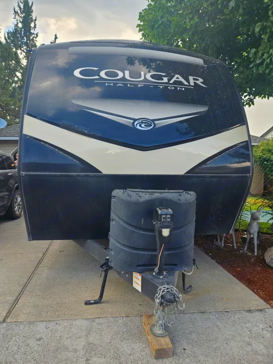 This Cougar Half-Ton travel trailer RV rental is shown head-on, with its distinct black/beige front and hitch.. Keystone RV Cougar 2019
