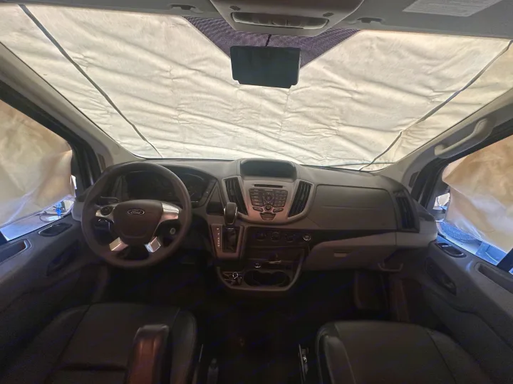 Inside an RV rental van, custom windshield and side window shades provide privacy and thermal insulation.. Winnebago Fuse 2017