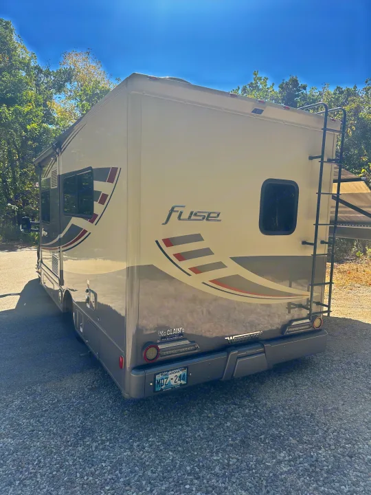 Rear view of a Winnebago Fuse RV rental, a sleek motorhome parked on gravel, ready for travel.. Winnebago Fuse 2017