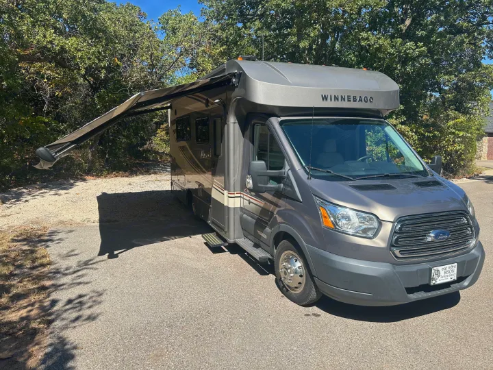Explore nature with this comfortable grey Winnebago rv rental, featuring an extended awning for outdoor relaxation.. Winnebago Fuse 2017