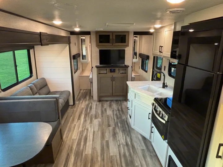 Spacious RV rental interior featuring a modern kitchen, comfortable dinette, and entertainment area with wood floors.. Jayco Jay Flight SLX 2024