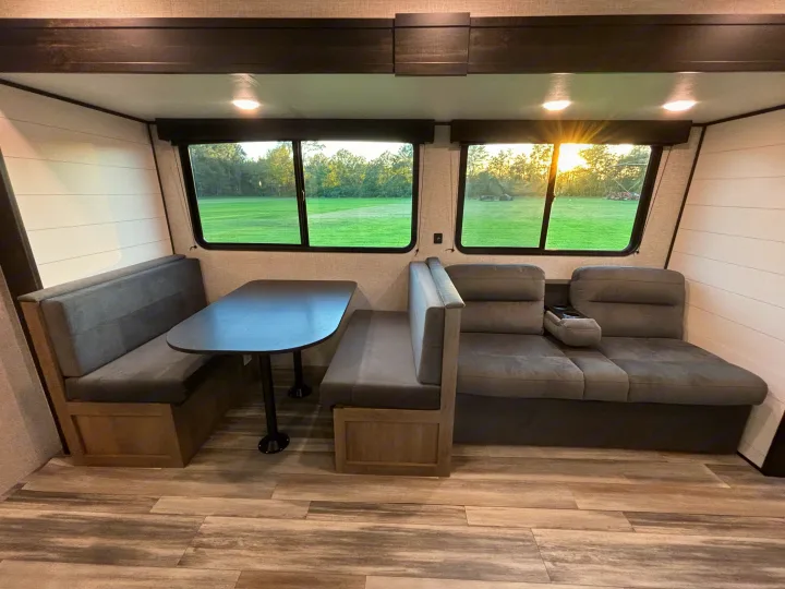 Inside an RV rental: comfy dinette, plush sofa seating, and bright windows with nature views.. Jayco Jay Flight SLX 2024