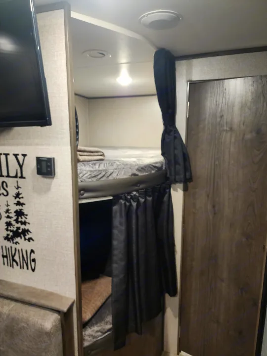 RV rental interior showing cozy bunk beds with privacy curtains, ideal for family travel.. Jayco Jay Flight SLX Rocky Mountain Edition 2020