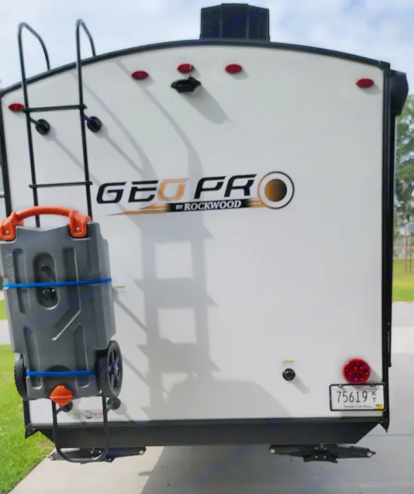 Rear of GEO PRO RV rental travel trailer, with a ladder, backup camera, and portable waste tank.. Forest River Rockwood Geo Pro 2022