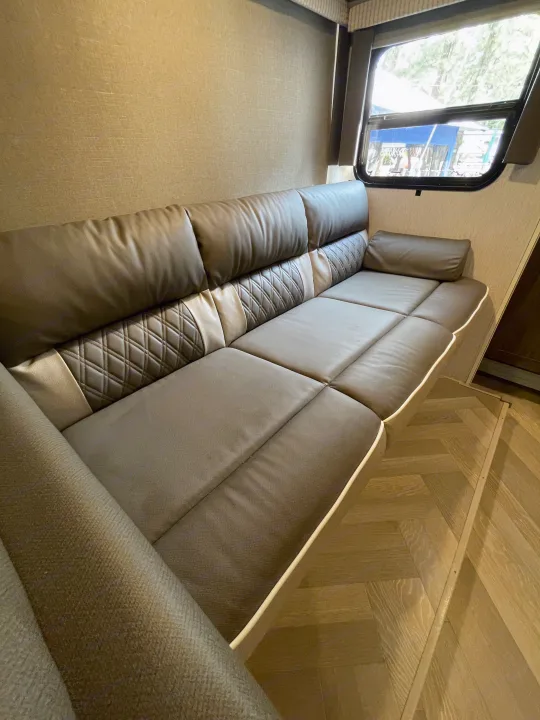 Spacious, modern RV rental interior with comfortable taupe and brown modular seating and a large window.. Forest River Salem Cruise Lite 2022