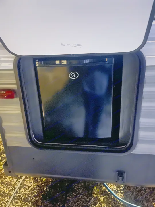 RV rental: Open exterior compartment reveals a black mini-fridge, ideal for outdoor beverages & camping.. Dutchmen 26bhc 2024