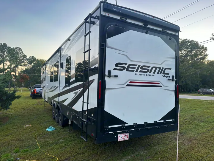 Spacious white & black Jayco Seismic RV rental (luxury toy hauler) parked on grass, ready for adventure.. Jayco Seismic 2023