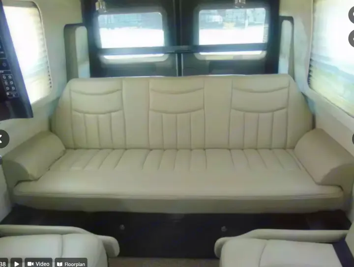 RV rental interior with a cream-colored convertible sofa bed stretching across the rear for comfortable travel.. Airstream Interstate 2014