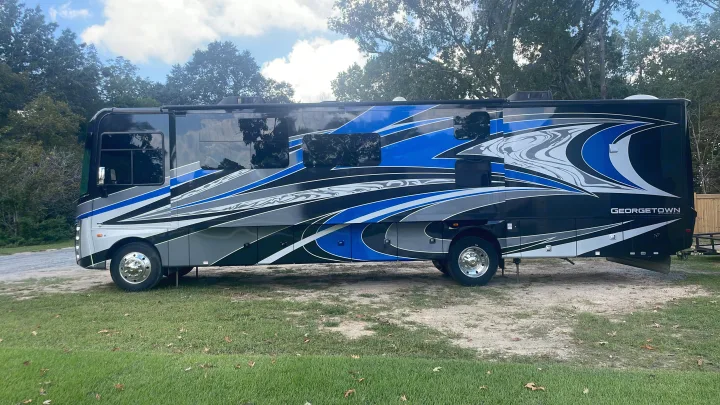 A sleek black, blue, and gray Georgetown motorhome parked outdoors. Perfect for your next rv rental adventure!. Georgetown GT7 2022
