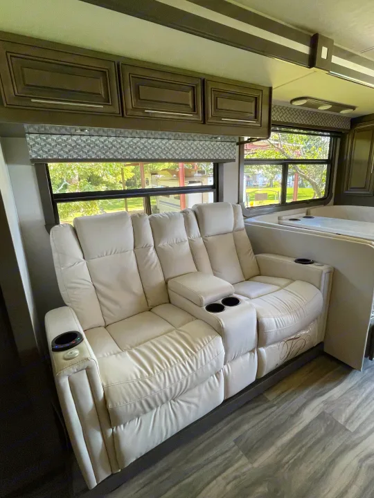 RV rental: light reclining theater seats with cup holders, dark cabinets, and patterned window valances.. Georgetown GT7 2022