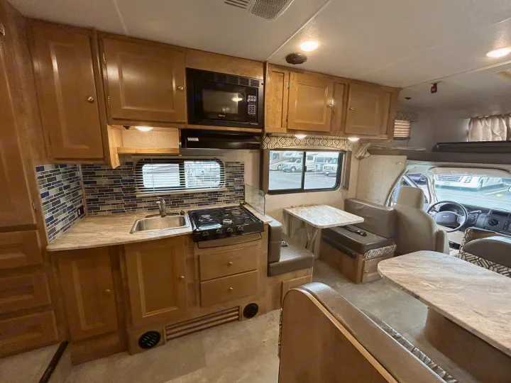 Spacious RV rental interior with full kitchen, dining area, and comfortable seating, ideal for travel.. Coachmen Leprechaun 2020