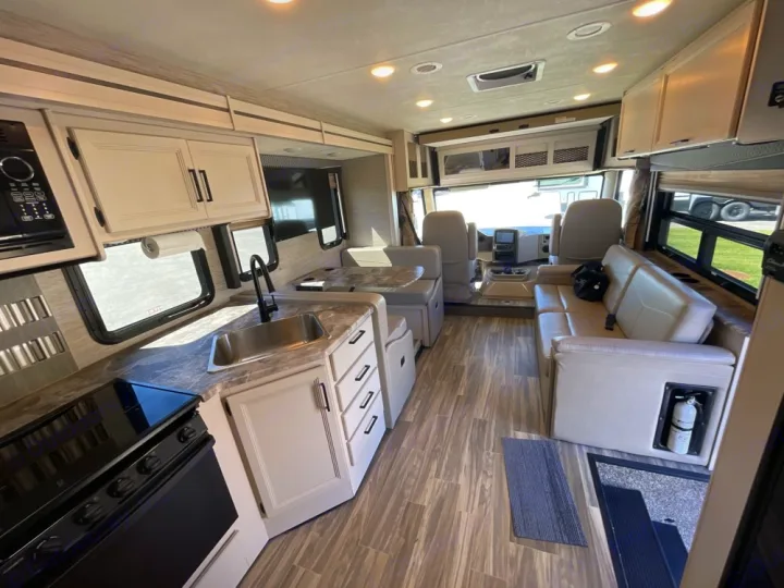 Spacious RV rental interior features a modern kitchen, comfortable living area, and driver's cockpit.. Thor A.C.E. 2020
