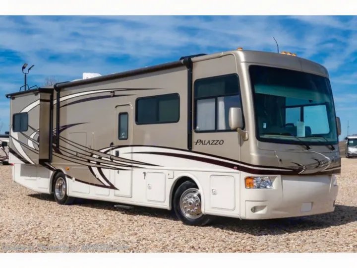 Spacious tan Palazzo RV rental parked on gravel. This motorhome is ready for your next travel adventure.. Thor Palazzo 2013