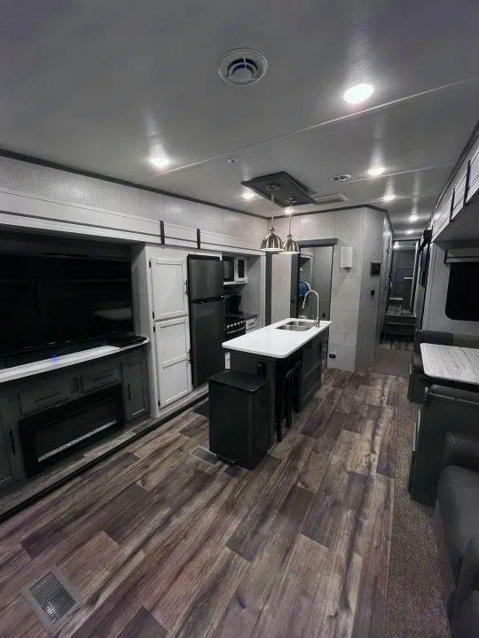 This modern RV rental features a full kitchen island, cozy living area with TV & fireplace, and ample space.. Volante 375MD 2023