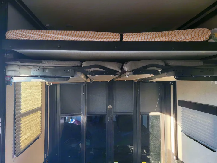 RV rental's spacious interior: Upper bunk bed, convertible lower seating, and rear ramp door. Ideal for family camping trips.. Grand Design Momentum 2022