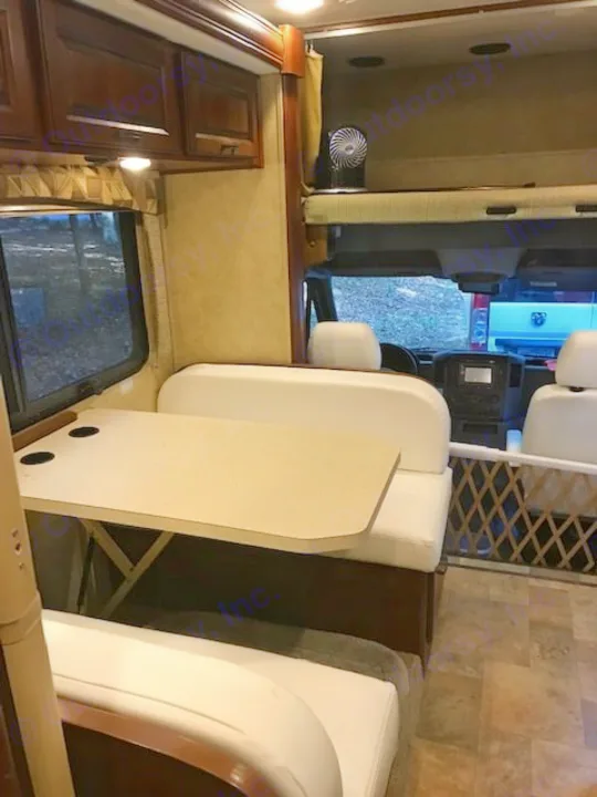 Explore this RV rental's interior: dinette, overhead bunk, and cockpit view. Perfect for comfortable travel.. Forest River Solera 24R 2014