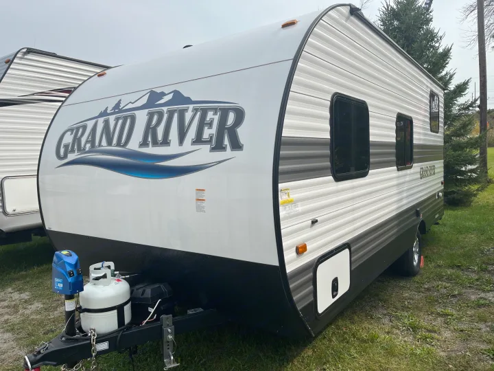 White and gray Grand River travel trailer, front and side view, showing propane tanks. Ideal for an rv rental.. Gulf Stream grand river 2024