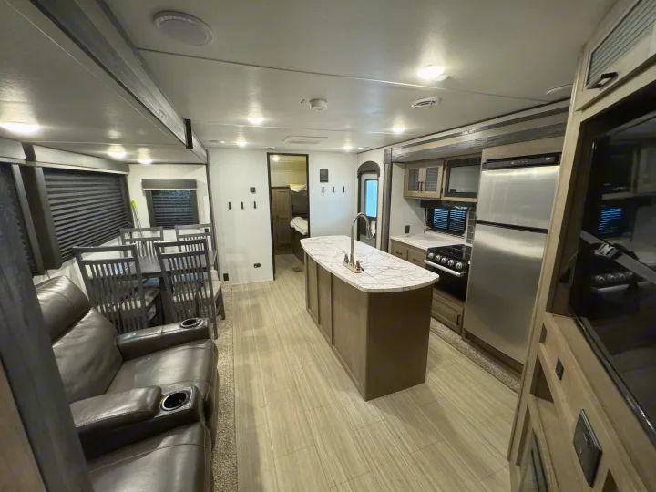 Spacious and modern RV rental interior featuring a full kitchen, dining area, and comfortable living space.. Keystone Hideout 2021