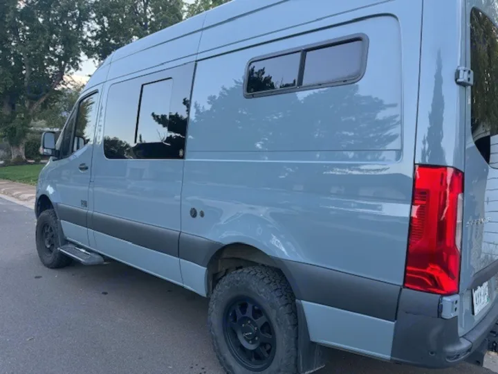 Explore in this light blue-grey rv rental camper van, equipped with tinted windows & all-terrain tires. Ready for your next adventure.. Mercedes-Benz Sprinter 2021