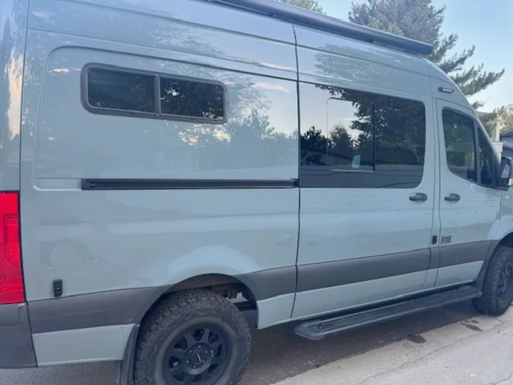 This light grey-blue adventure van is ideal for your next RV rental. Equipped with off-road tires and a roof awning.. Mercedes-Benz Sprinter 2021