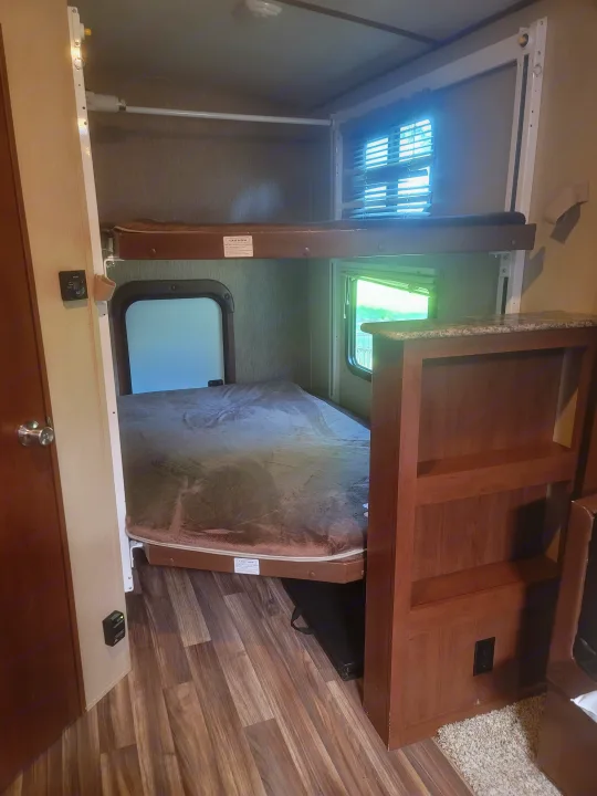 Spacious RV rental interior with comfortable bunk beds and a large lower bed, perfect for family adventures.. Denali Lite 2015