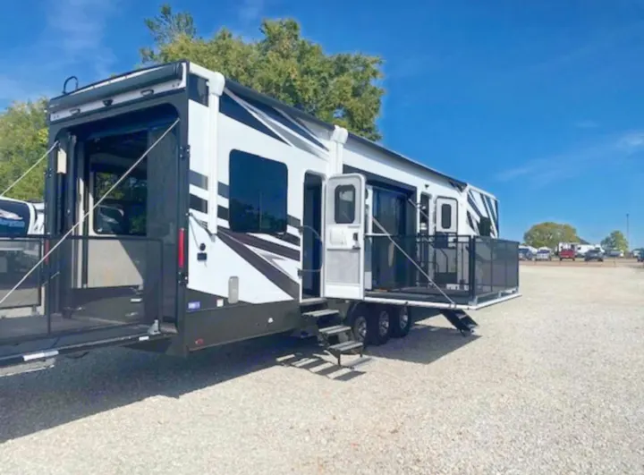 Spacious toy hauler RV rental on gravel lot with multiple deployed patios. Ideal for outdoor adventures.. Jayco Seismic 2023