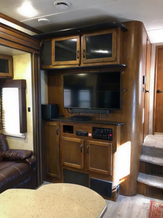 Experience this **rv rental's** entertainment center: TV, soundbar, and a comprehensive control panel for your travel comfort.. Keystone RV Carbon Toy Hauler 2015